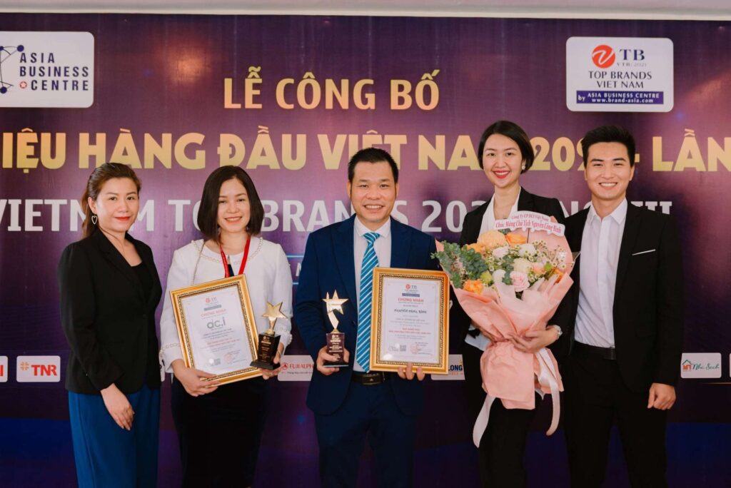 Ông Nguyễn Công Bình (đứng giữa) cùng đội ngũ DCI phấn khởi tại Lễ công bố Thương hiệu hàng đầu Việt Nam 2021
